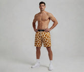 Man wearing giraffe print shorts on a plain background