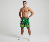 Man wearing green swim shorts with white star design on a plain background