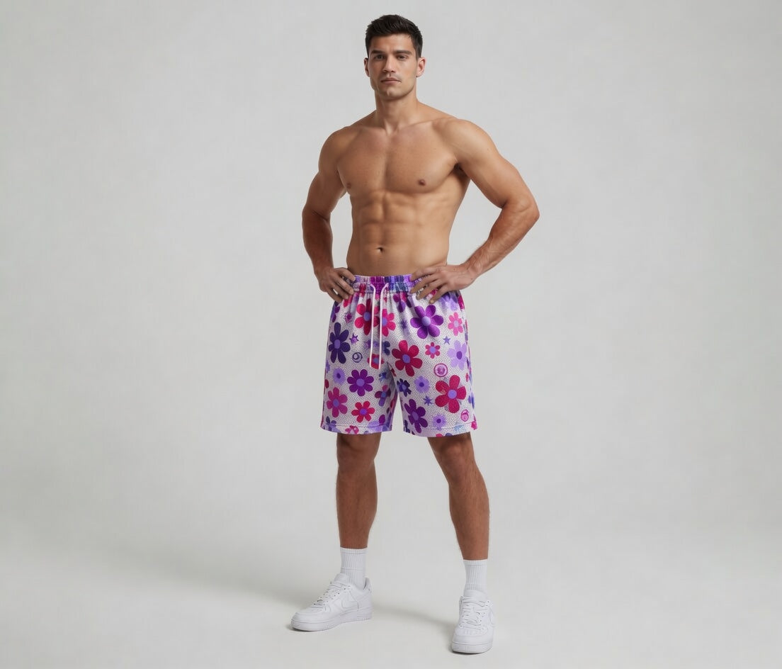Man wearing colorful floral shorts on a plain background
