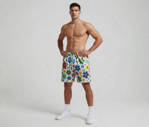Man wearing colorful floral shorts on a plain background