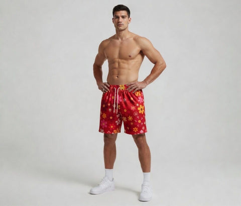 Man wearing red floral swim shorts on a plain background